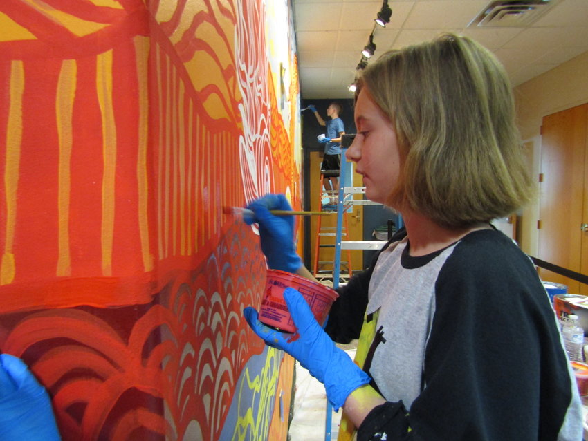 Alyssa Kuhn, 11, touches up lines on the mural at Buchanan Park Recreation Center.